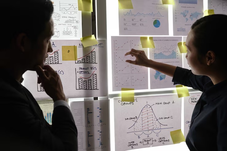 imgi_16_male-female-colleagues-standing-by-window-looking-business-graphs-it_1098-20205
